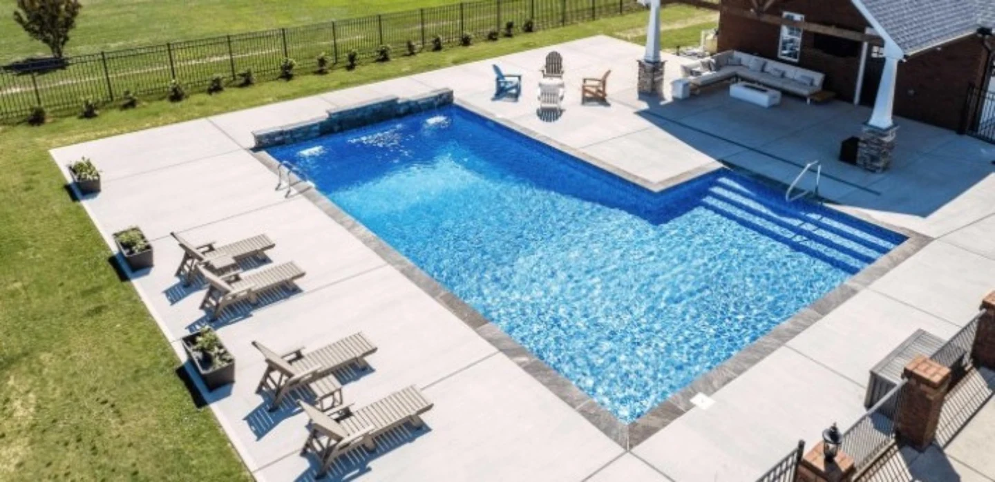 Rectangular in-ground pool with integrated steps and concrete pool deck